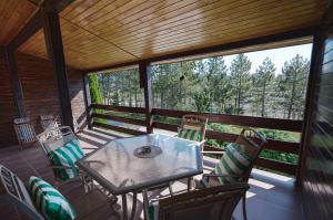 a screened in porch with a table and chairs at The Greens Family House in Zlatibor