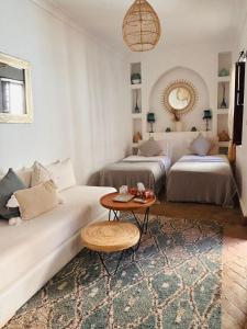 a living room with two beds and a table at Riad Dar Elma And Spa in Marrakesh