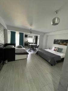 um quarto com 2 camas, uma mesa e cadeiras em Welcome to Bucharest Airport Residences & Therme-SELF CHECK-IN em Otopeni