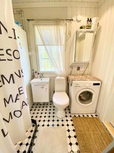 a small bathroom with a toilet and a washing machine at Villa Tilda in Matildedal +30 photos