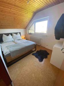 ein Schlafzimmer mit einem Bett in einem Zimmer mit einem Fenster in der Unterkunft Ruhige Wohnung im Schwarzwald in Villingen-Schwenningen