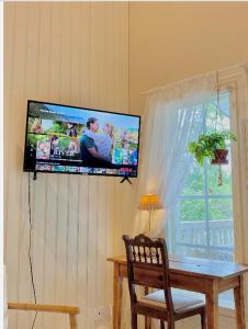 a flat screen tv hanging on a wall with a table at Villa Tilda in Matildedal
