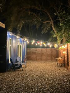 a patio at night with a fence and lights at Entirely Private Tiny Home - 1 Mile to UF in Gainesville