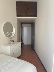 una camera con letto bianco e specchio di Il Vicoletto nel centro storico di Frascati a Frascati