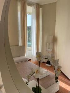 a mirror with flowers in a room with a window at 'Il Vicoletto' nel centro di Frascati in Frascati