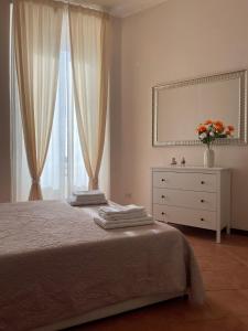 una camera con letto, cassettiera e specchio di Il Vicoletto nel centro storico di Frascati a Frascati