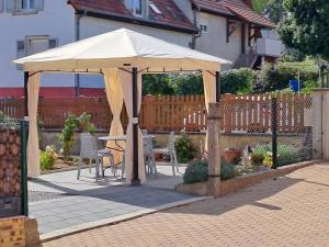 una sombrilla blanca en un patio con mesa y sillas en Maison Maurer, en Aschbach