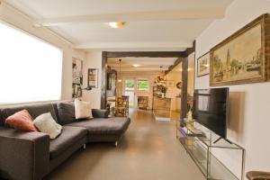 a living room with a couch and a television at Boutique Studio ter Westenschouwen in Westenschouwen