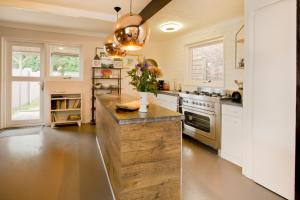 a kitchen with white cabinets and a large island at Boutique Studio ter Westenschouwen in Westenschouwen