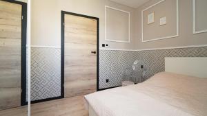 a bedroom with a white bed and a sliding door at Przytulny elegancki APARTAMENT przy dworcu in Elblag