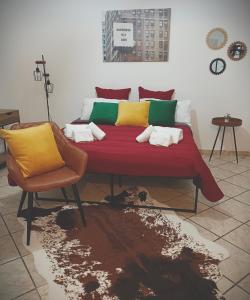 Habitación con cama, silla y mesa. en Vichome en Catania