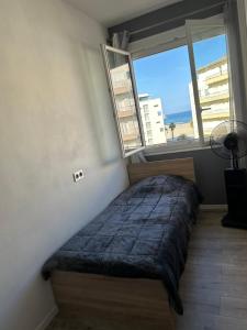 a bedroom with a bed and a large window at MAGNIFIQUE VUE MER Place Centrale F2 45 m2 tout confort Travaux en cours sur façade in Canet-en-Roussillon
