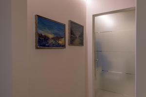 two pictures hanging on a wall next to a door at In Riva al Lago di Iseo Dependance Piano Terra in Marone