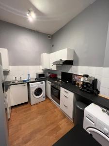 a kitchen with white cabinets and a washer and dryer at CENTRAL BIRMINGHAM 3 Bedroom 3 Bed Apartment in Birmingham