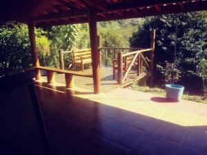 a wooden deck with a bench and a wooden bridge at Vila Linda Flor in São José dos Campos