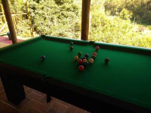 a green pool table with balls on top of it at Vila Linda Flor in São José dos Campos