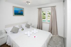 a white bedroom with a white bed and a window at Villa Hera Sevid in Sevid +40 photos