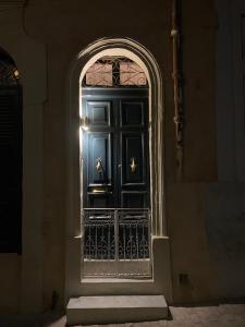 una entrada a un edificio con una puerta negra en Birgu No 25 apartment 2, en Birgu