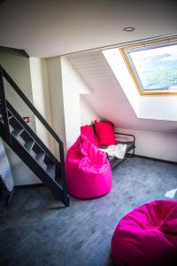 ein Dachzimmer mit zwei Sitzsäcken und einem Fenster in der Unterkunft Bienvenue dans le violine 2 à 6 couchages in Cholonge