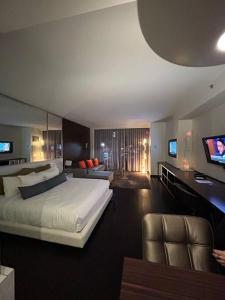 a bedroom with a large white bed and a couch at Amazing view 18th floor at Palms place Las Vegas in Las Vegas