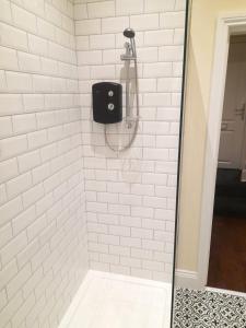 a shower with a black soap dispenser in a bathroom at Kirkcudbright Holiday Apartments - Apartment D in Kirkcudbright