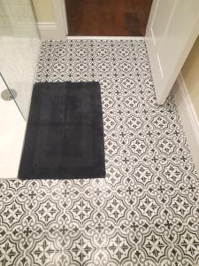 a black rug on a tile floor in a bathroom at Kirkcudbright Holiday Apartments - Apartment D in Kirkcudbright