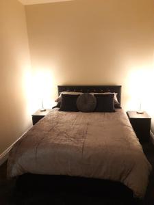 a bedroom with a large bed with two lamps at Kirkcudbright Holiday Apartments - Apartment D in Kirkcudbright