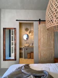 a bedroom with a mirror and a bathroom with a sink at PUUR aan de Zeeuwse kust in Wemeldinge