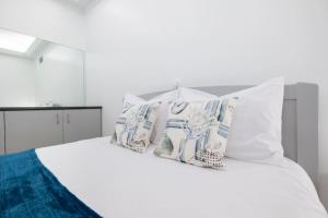 Una cama blanca con cuatro almohadas. en Nature Apartment by GALMI, en Ponta do Sol