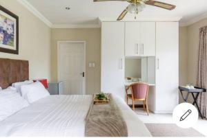 a bedroom with a large white bed with a ceiling fan at Jewel of Jozi in Edenvale +32 photos