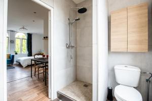 a bathroom with a shower and a toilet and a bedroom at Appartement Lumineux et cozy à LILLE Lomme in Lille