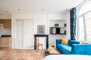 uma sala de estar com um sofá azul e uma mesa em Appartement Lumineux et cozy à LILLE Lomme em Lille