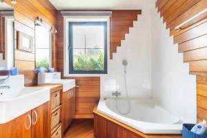 een badkamer met een bad, een wastafel en een trap bij Superbe et chaleureux gîte familial in Beauraing