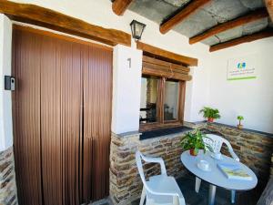 a patio with a table and chairs and a wooden door at Muley Hacén in Capileira