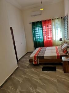 1 dormitorio con 1 cama con cortinas coloridas en TAYKI, en Cotonou