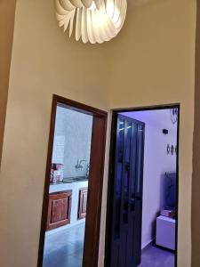 Habitación con cocina con lámpara de araña y puerta. en TAYKI, en Cotonou