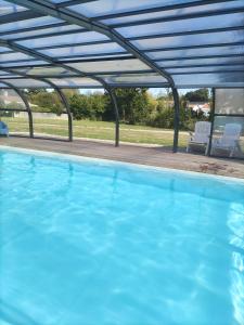 a large blue swimming pool with a pergola at Maison avec piscine privée, proche plage in Avrillé