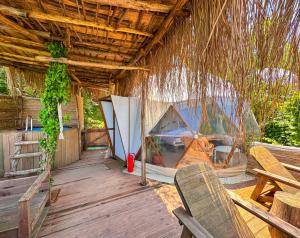 薩潘賈的住宿－Sapanca Dome Glamping，一间在甲板上配有帐篷和椅子的房间