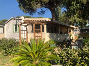 a house that is being remodeled with a tree at Mobilhome 6 personnes Camping Oasis Village 5 étoiles in Puget-sur Argens