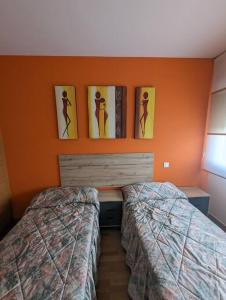 ein Schlafzimmer mit 2 Betten und Bildern an der Wand in der Unterkunft Piso completo y moderno, Burgos in Burgos