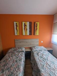 a bedroom with two beds and pictures on the wall at Piso completo y moderno, Burgos in Burgos