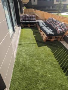 a patio with two couches sitting on the grass at Piso completo y moderno, Burgos in Burgos