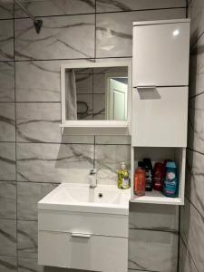 a bathroom with a sink and a mirror at Spacious & cozy apartment, free parking, contact-free entrance in Tartu