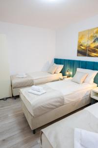 a room with three beds and a painting on the wall at Hidden Gem in Mostar