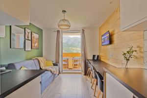 cocina y sala de estar con sofá y mesa en Studio de charme avec vue sur le Val d'Allos, parking et Wifi gratuit, en Allos
