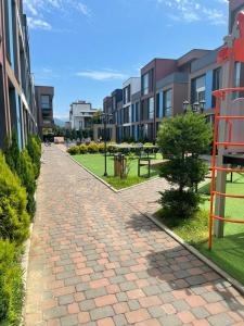 a brick walkway next to some buildings on a street at Liana Polo Villas Parklane in Batumi