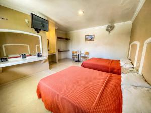 a hotel room with two beds and a television at Villa Meztli in San Juan Teotihuacán