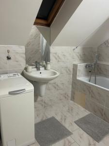 a white bathroom with a sink and a bath tub at Mezonet Svítkov 21 in Pardubice