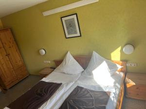 a bedroom with a bed with white sheets and pillows at Hotel Eifeltor in Mechernich