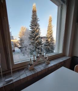 Un árbol de Navidad en una ventana con velas en Quiet studio - easy check-in, free parking & wifi, en Rovaniemi